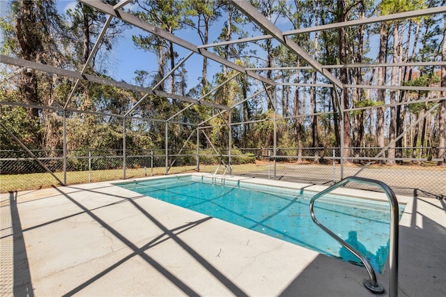 view of swimming pool with a patio area, fence, a fenced in pool, and a lanai