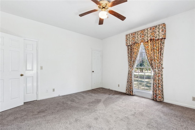 carpeted empty room with a ceiling fan