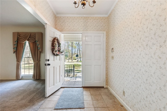 entryway with ornamental molding, a healthy amount of sunlight, and wallpapered walls