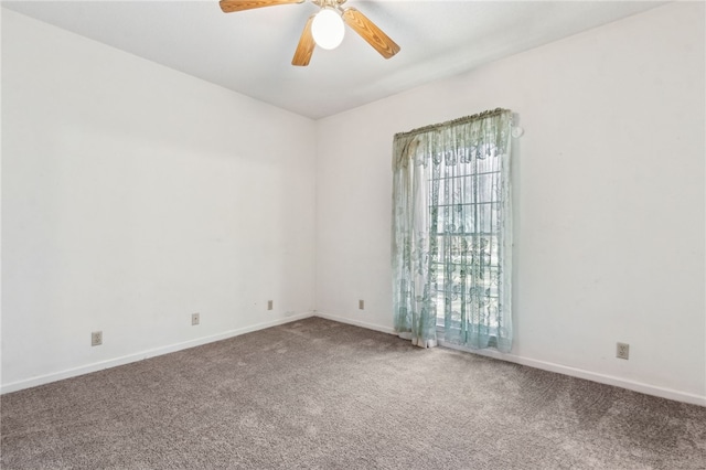 carpeted spare room with a ceiling fan and baseboards