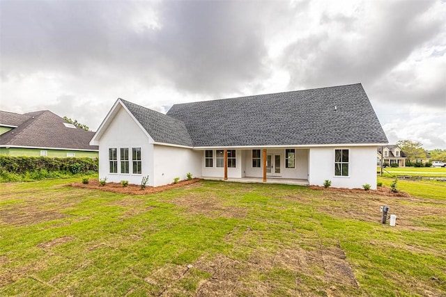 225 Water Crest Dr, Brunswick, GA 31523 - view of front facade with a front yard, stucco siding, a shingled roof, and a patio