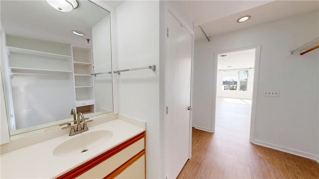 bathroom with recessed lighting, wood finished floors, and vanity