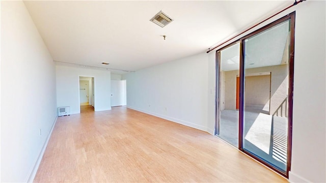 spare room with visible vents, baseboards, and light wood finished floors