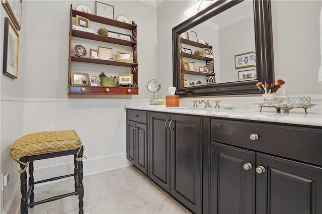 bathroom with vanity, ornamental molding, and wainscoting