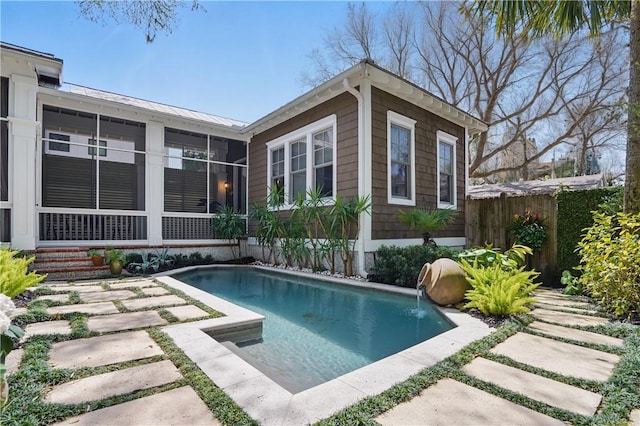 view of swimming pool with a sunroom, a fenced in pool, and fence