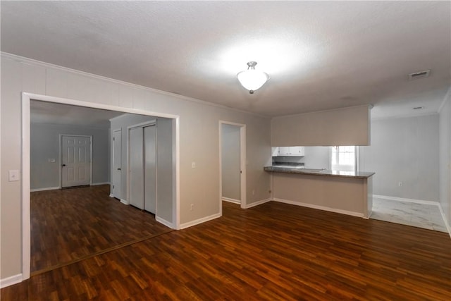 907 Euclid Ave, Waycross, GA 31501 - unfurnished living room featuring ornamental molding and dark wood finished floors