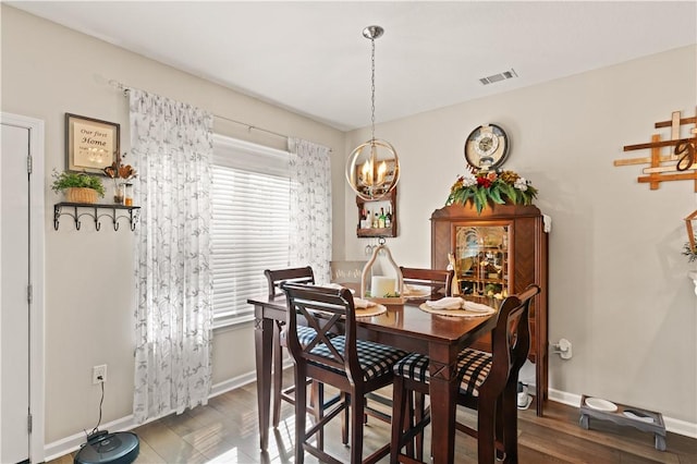 dining room with a chandelier, baseboards, and wood finished floors