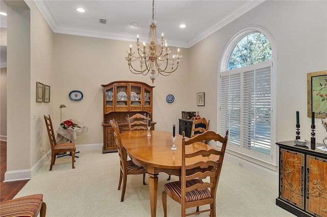 dining room with plenty of natural light, crown molding, and a notable chandelier