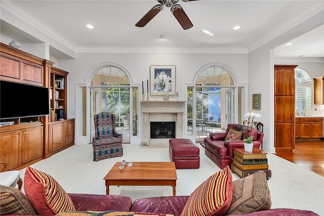 living room with light hardwood / wood-style floors, ceiling fan, ornamental molding, and sink