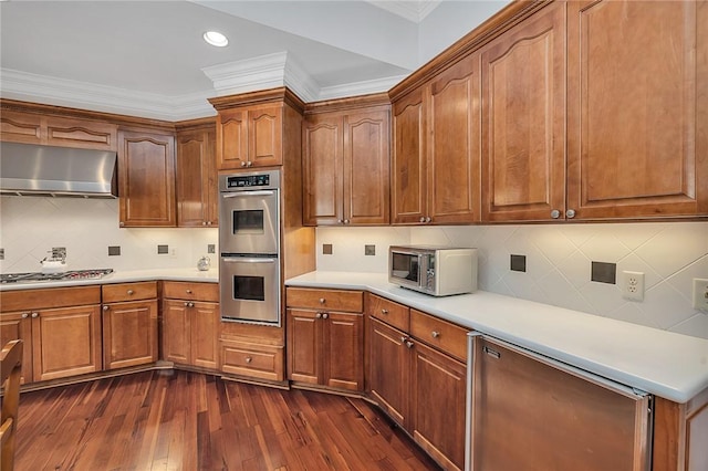 kitchen with appliances with stainless steel finishes, backsplash, dark hardwood / wood-style flooring, and crown molding