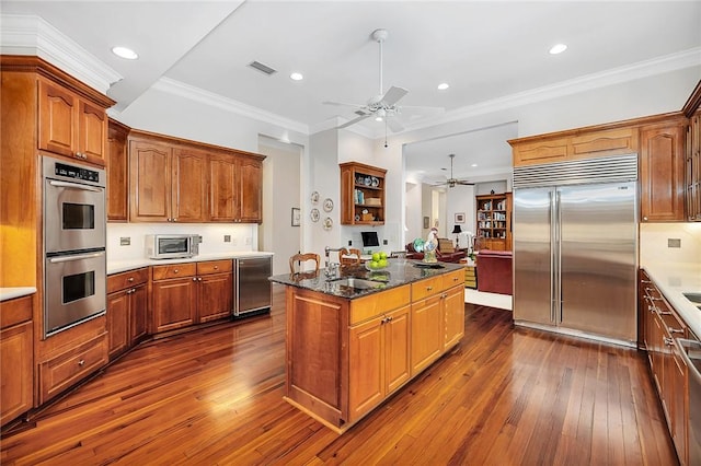 kitchen with decorative backsplash, a center island, crown molding, and appliances with stainless steel finishes