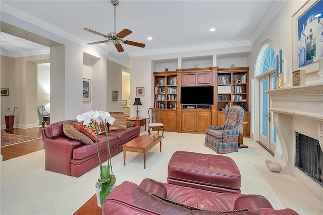 carpeted living room featuring ceiling fan and ornamental molding