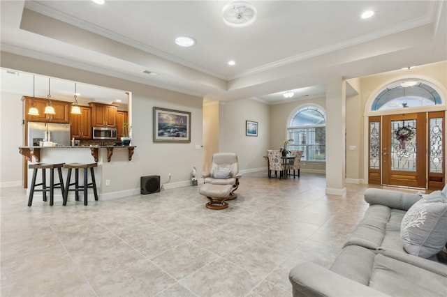 living room with crown molding and a raised ceiling