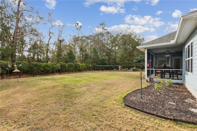 view of yard with ceiling fan and a sunroom