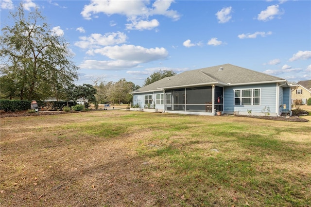 rear view of property with a sunroom and a yard