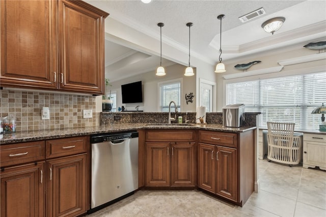 kitchen with sink, dishwasher, a tray ceiling, decorative light fixtures, and dark stone counters