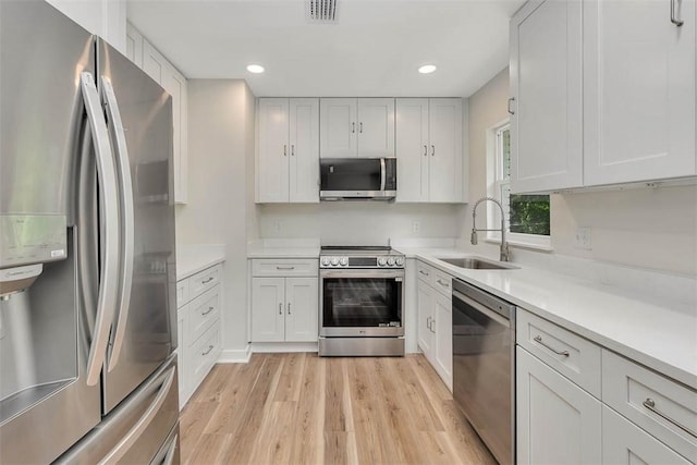 515 Nottingham Dr, Brunswick, GA 31525 - kitchen featuring stainless steel appliances, light wood-style flooring, light countertops, recessed lighting, and white cabinetry