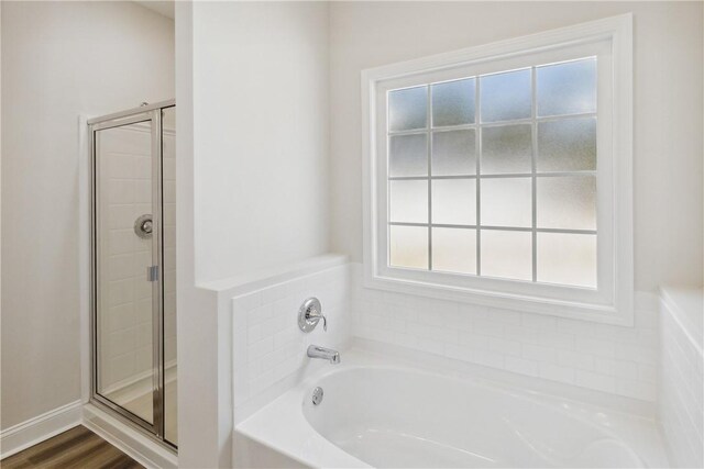 bathroom with hardwood / wood-style floors and independent shower and bath