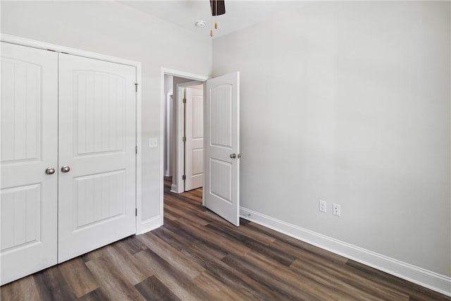 unfurnished bedroom with dark hardwood / wood-style flooring, a closet, and ceiling fan