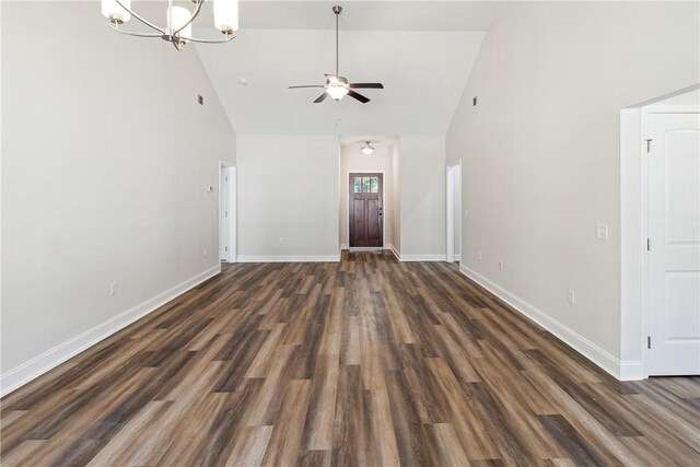 unfurnished living room featuring high vaulted ceiling, dark wood-type flooring, and ceiling fan with notable chandelier