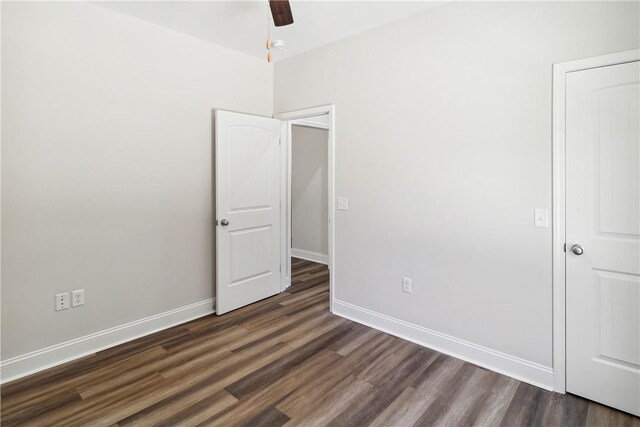 unfurnished bedroom featuring ceiling fan and dark wood-type flooring