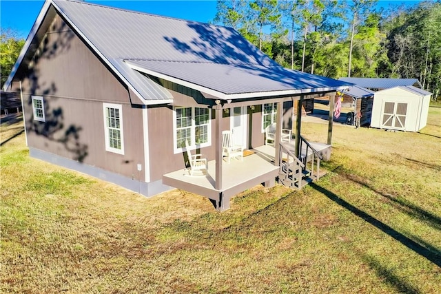 back of property with a yard and a storage unit