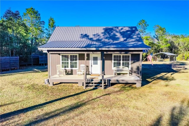 back of house with a lawn and a carport