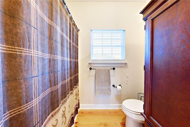 bathroom featuring wood-type flooring and toilet