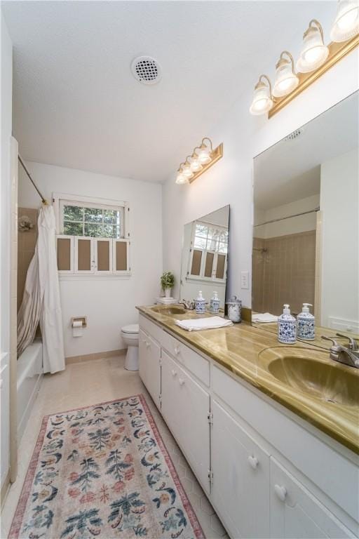 bathroom featuring toilet, a sink, double vanity, and shower / bathtub combination with curtain