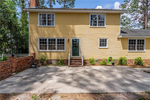 view of front of property featuring a chimney, fence, entry steps, a patio area, and crawl space