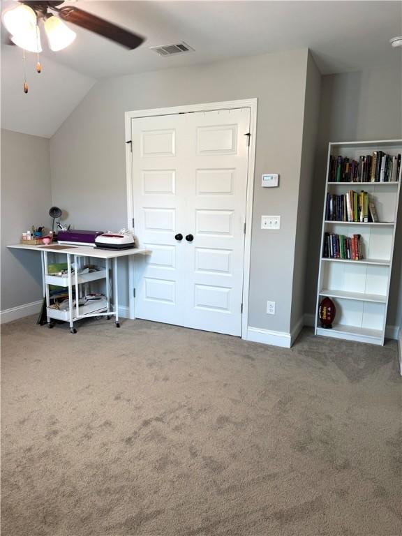 home office featuring visible vents, lofted ceiling, carpet, and ceiling fan