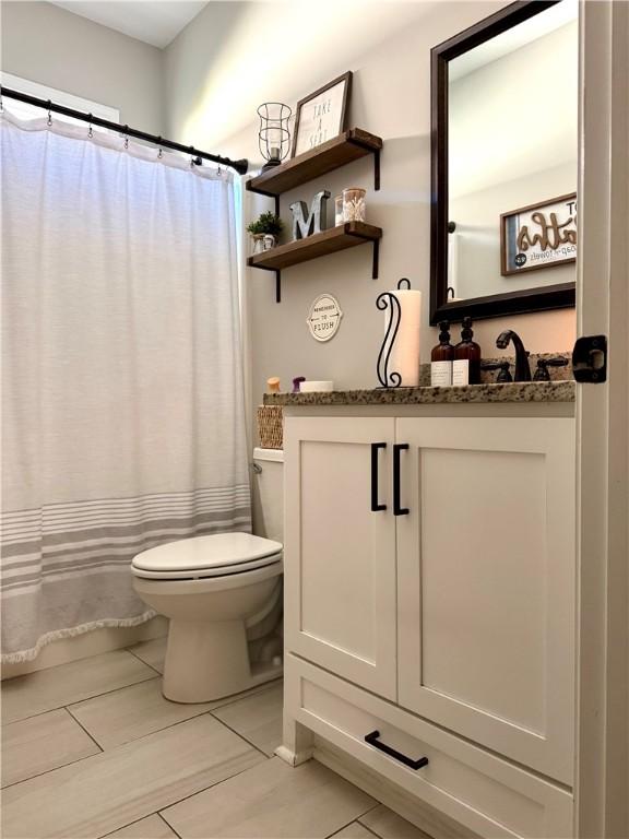 full bathroom featuring vanity, curtained shower, and toilet