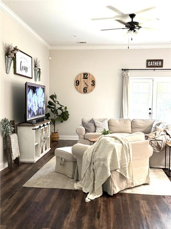 living area featuring crown molding, wood finished floors, and baseboards