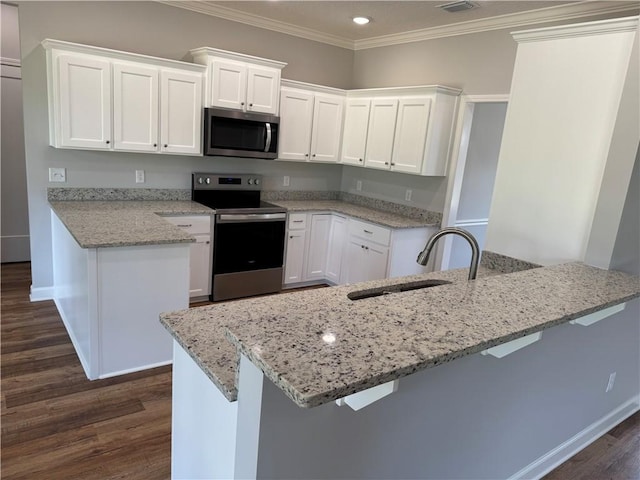 100 Haven Ct, Brunswick, GA 31523 - kitchen with stainless steel appliances, a sink, dark wood-style flooring, white cabinetry, and ornamental molding