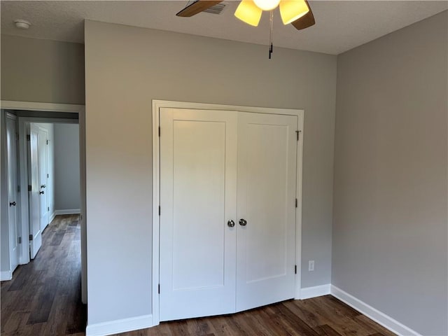 100 Haven Ct, Brunswick, GA 31523 - unfurnished bedroom with dark wood finished floors, baseboards, a closet, and ceiling fan