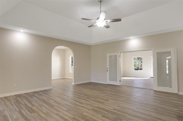 empty room with ceiling fan, light hardwood / wood-style floors, and french doors