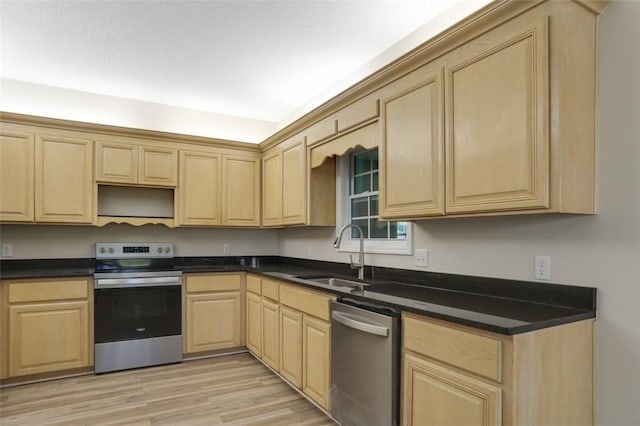 kitchen featuring sink, light brown cabinets, light hardwood / wood-style flooring, dark stone countertops, and appliances with stainless steel finishes