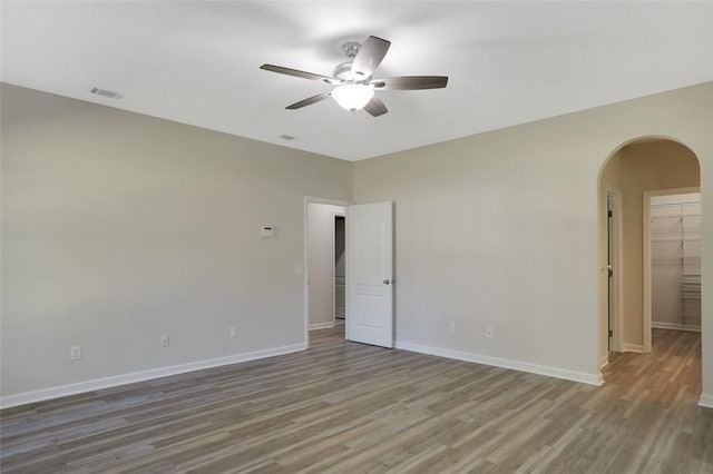 empty room with ceiling fan and hardwood / wood-style flooring