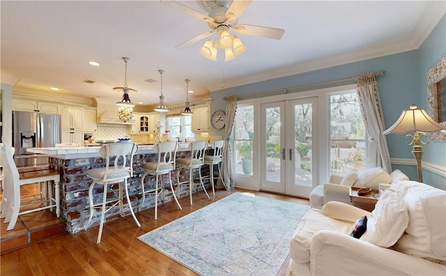 231 Magnolia Ave, Saint Simons Island, GA 31522 - living area with crown molding, french doors, a ceiling fan, wood finished floors, and recessed lighting