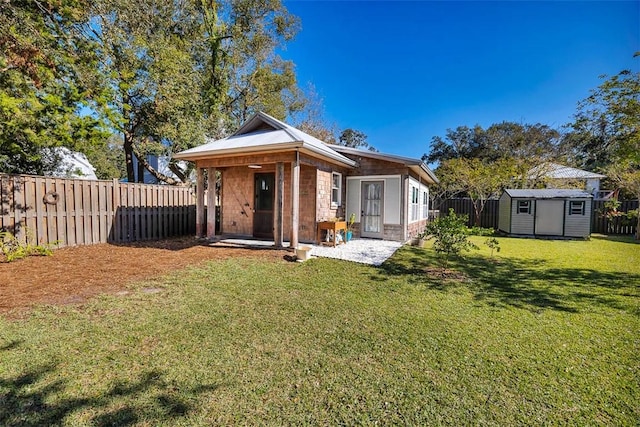 back of property with a storage unit and a lawn