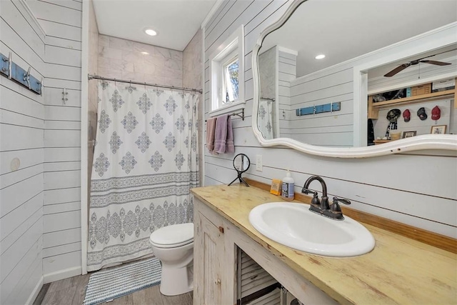 bathroom with wood walls, wood-type flooring, sink, and curtained shower