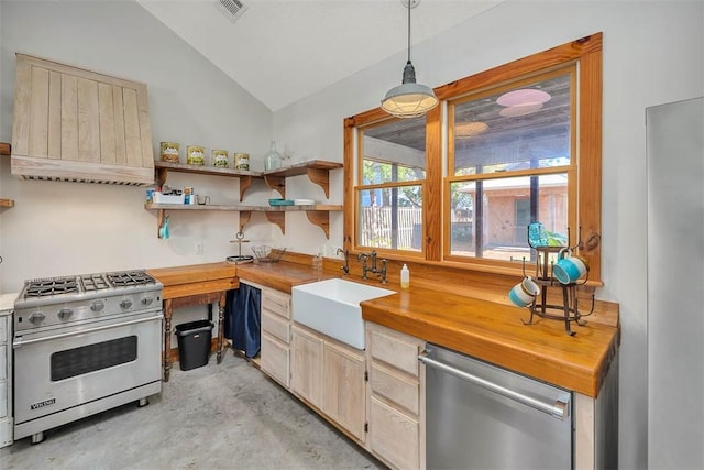 kitchen featuring wood counters, stainless steel appliances, hanging light fixtures, and sink