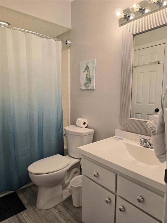 bathroom featuring hardwood / wood-style flooring, vanity, and toilet