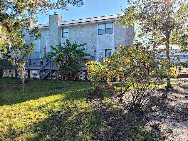 back of property featuring a yard and a deck