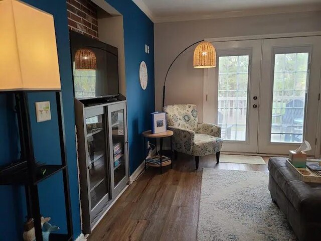 living area with french doors, ornamental molding, and wood-type flooring