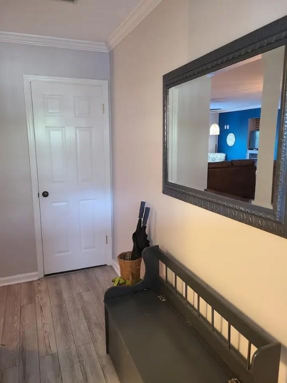 hall with crown molding and light hardwood / wood-style floors