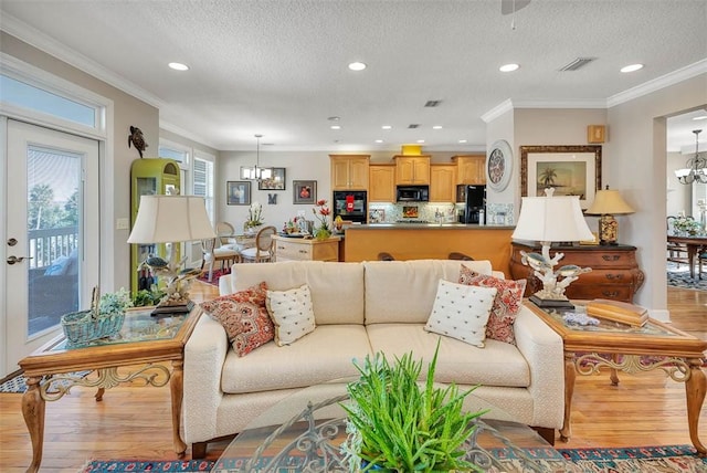 4153 River Side Dr, Brunswick, GA 31520 - living room featuring a chandelier, wood finished floors, recessed lighting, crown molding, and a textured ceiling