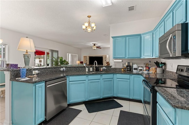 114 Shell Pointe Dr, Brunswick, GA 31525 - kitchen with a textured ceiling, ceiling fan with notable chandelier, blue cabinetry, and appliances with stainless steel finishes