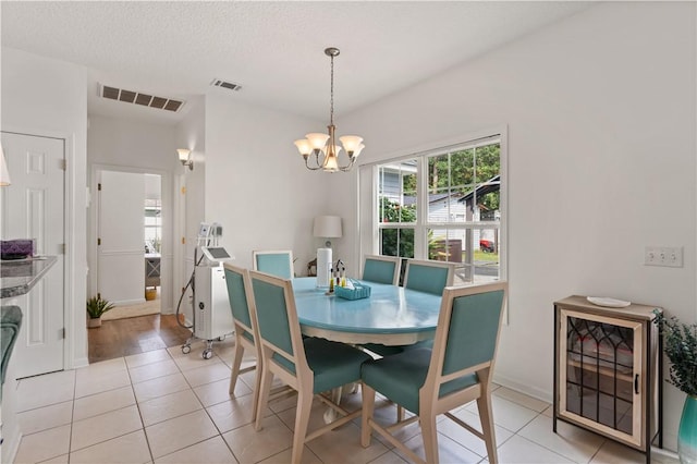 114 Shell Pointe Dr, Brunswick, GA 31525 - dining area with light tile patterned floors, a textured ceiling, and a notable chandelier
