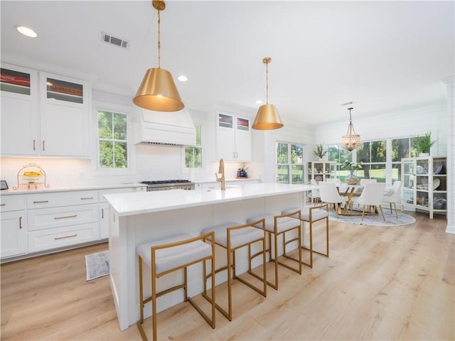 904 Champney, Saint Simons Island, GA 31522 - kitchen with light countertops, light wood-style flooring, backsplash, white cabinetry, and recessed lighting